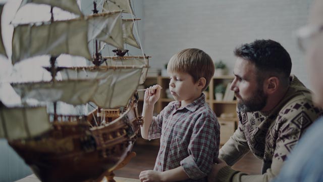 father and son playing with old ship small overlay
