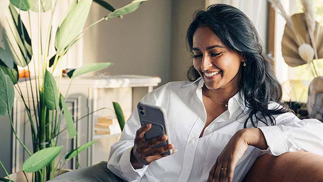 Tech savy woman in couch with mobil2 - Small